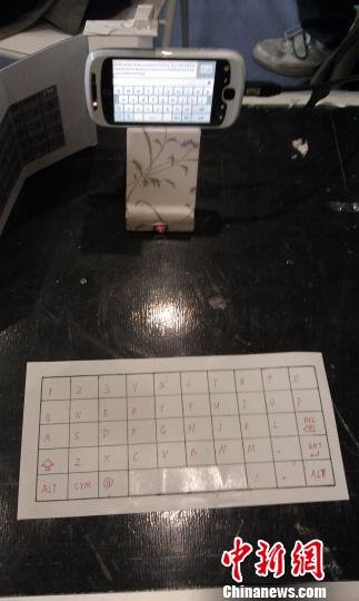圖為學(xué),F(xiàn)場(chǎng)演示紙鍵盤在手機(jī)上的應(yīng)用。黃靜攝